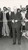 Black and white photo of a politician cutting a ribbon